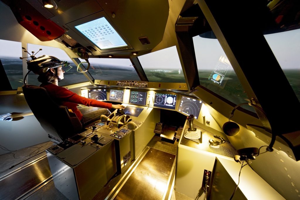 A woman controlling a flight simulator, learning to get a commercial pilot licence.