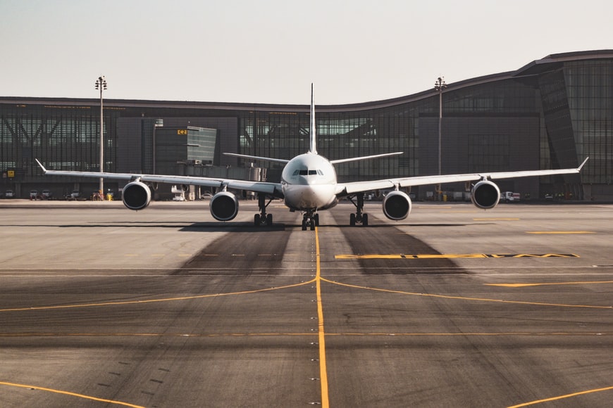 An airliner riding down a taxiway next to an airport terminal. 