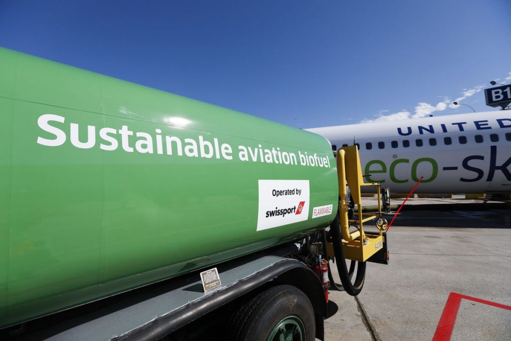 A central view of a sustainable aviation biofuel tank with United Airlines Eco-Skies aircraft in the background.