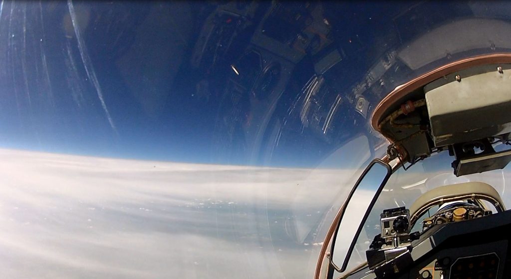 A MIG 29 fighter jet flying at a high altitude above clouds.