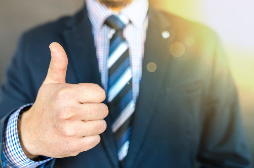 A representation of a successful leader: a businessman encouraging and showing a thumbs up.