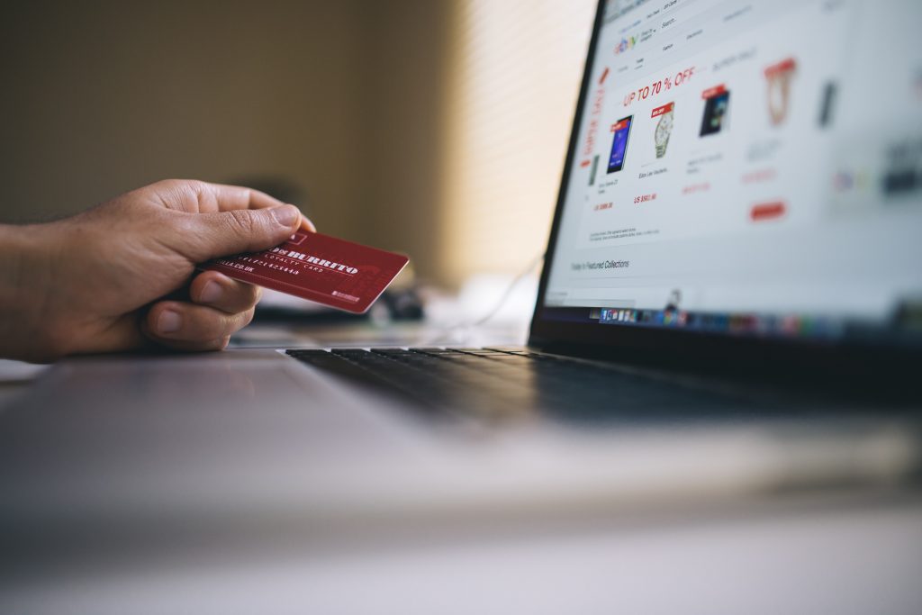 A customer browsing and shopping at an online store on a laptop, using their credit card. 