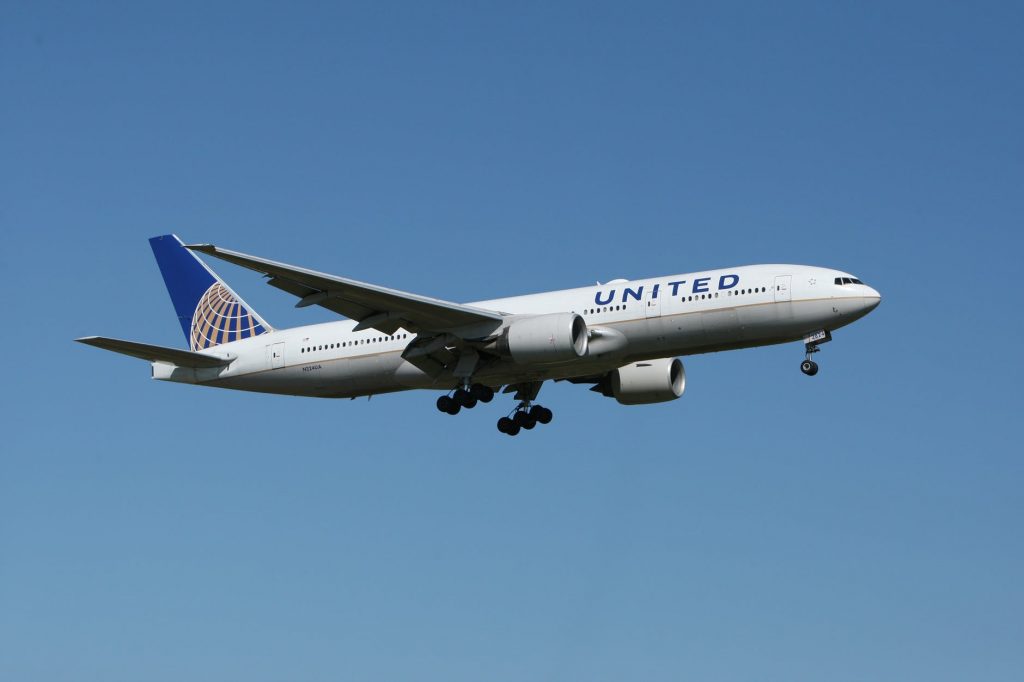 United Airlines airliner for passenger transportation flying through a clear sky. 