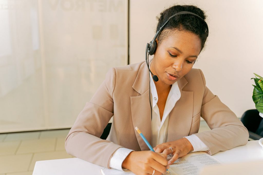 A woman with a headset working as a customer service representative with live help desk.