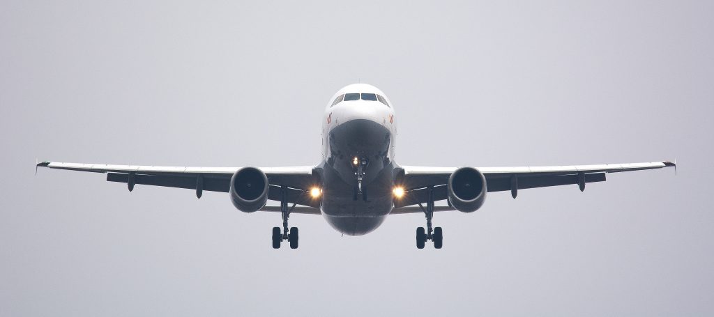 A passenger aircraft ready to land at an airport on a cloudy day.