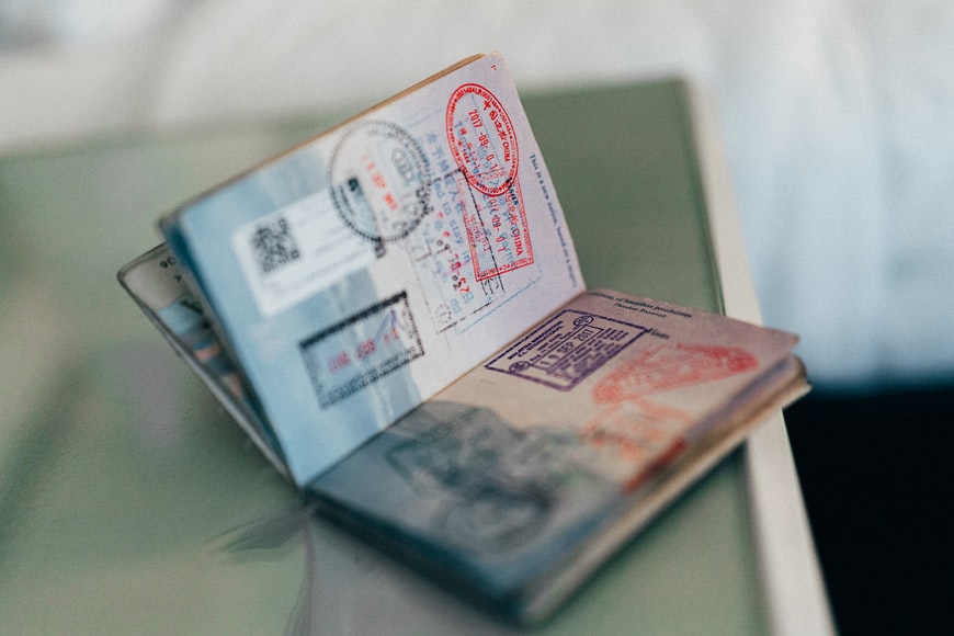 A passport with a valid travel document number and valid visa stamps.
