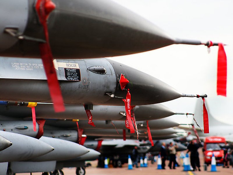 Fighter jets marked with tags "remove before flight" parked at an airfield.