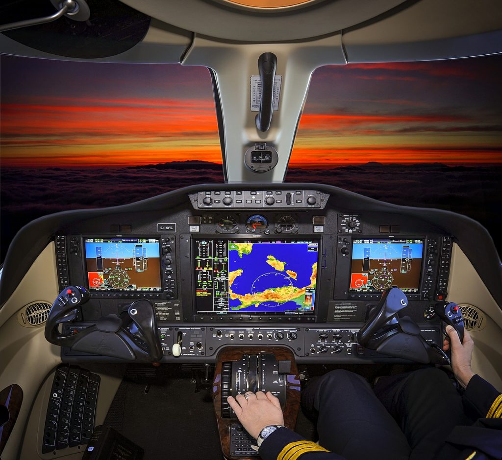 A central view of an aircraft's cockpit with a functioning instrument panel and navigation systems. 