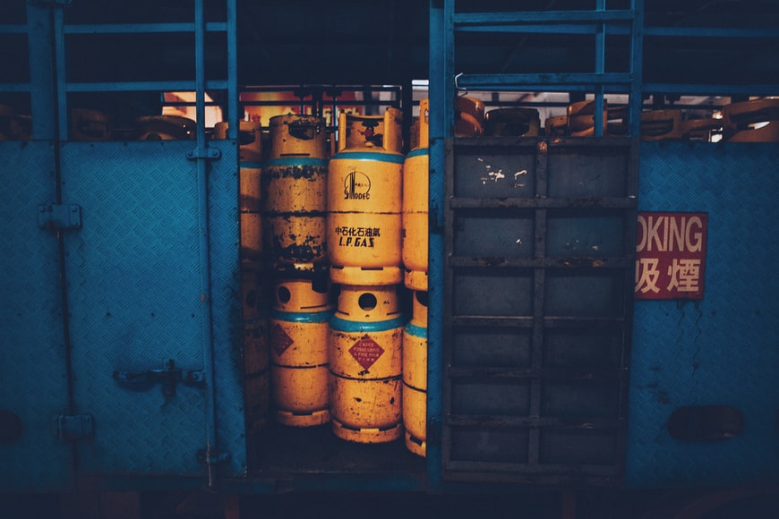 Stacked yellow gas barrels ready to be transported as dangerous goods. 