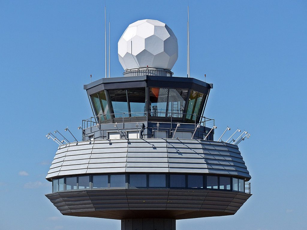 A central view of an air traffic control tower at an airport. 