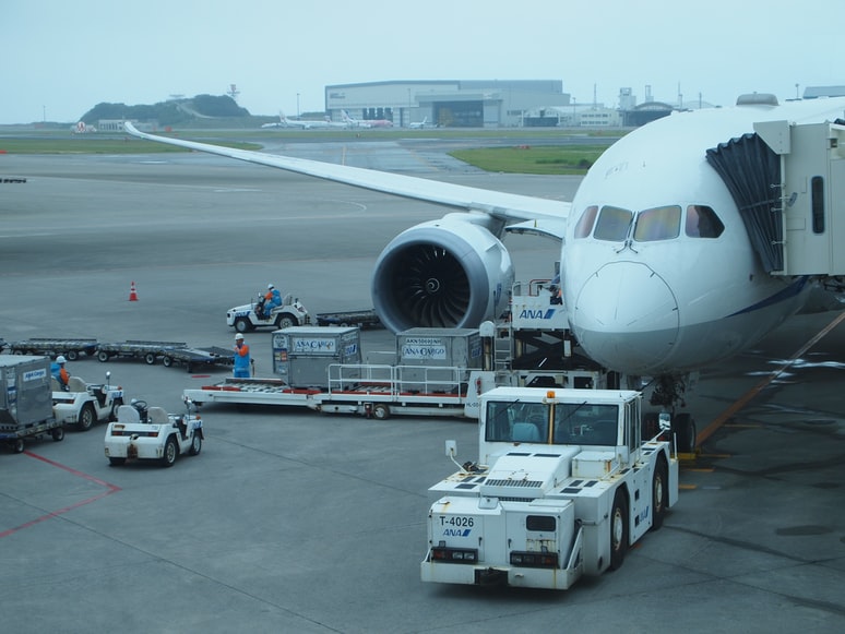 Freight and cargo being loaded into an transport aircraft docked at a jet way.