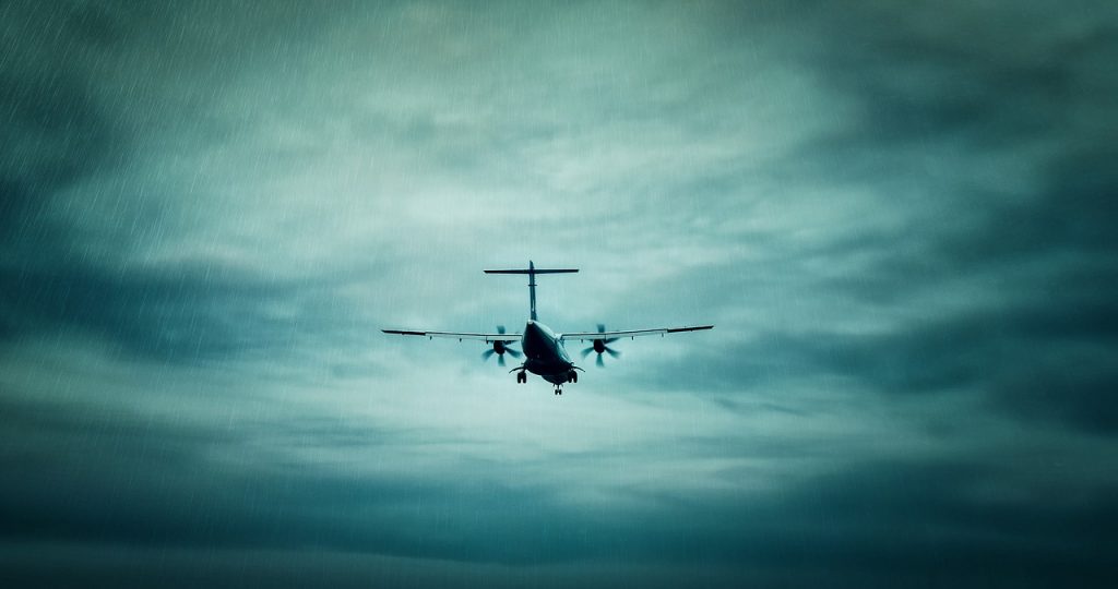 A small propeller-powered aircraft flying through the rain.