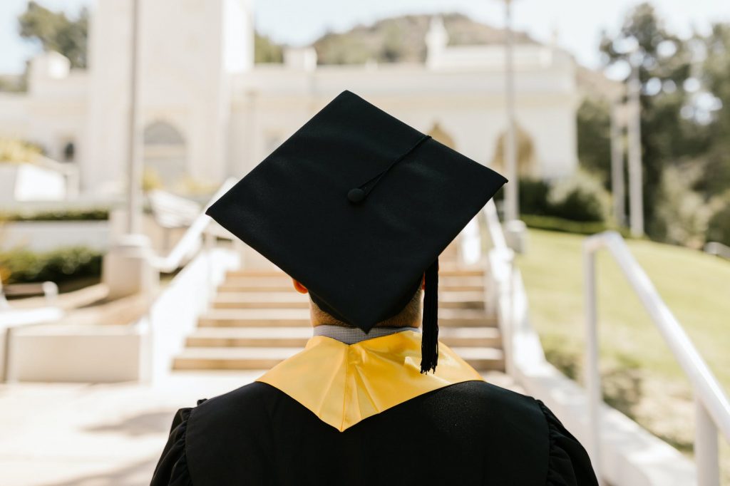 A student graduating from a Bachelor's or Master's degree, wearing a university robe and a graduation cap.