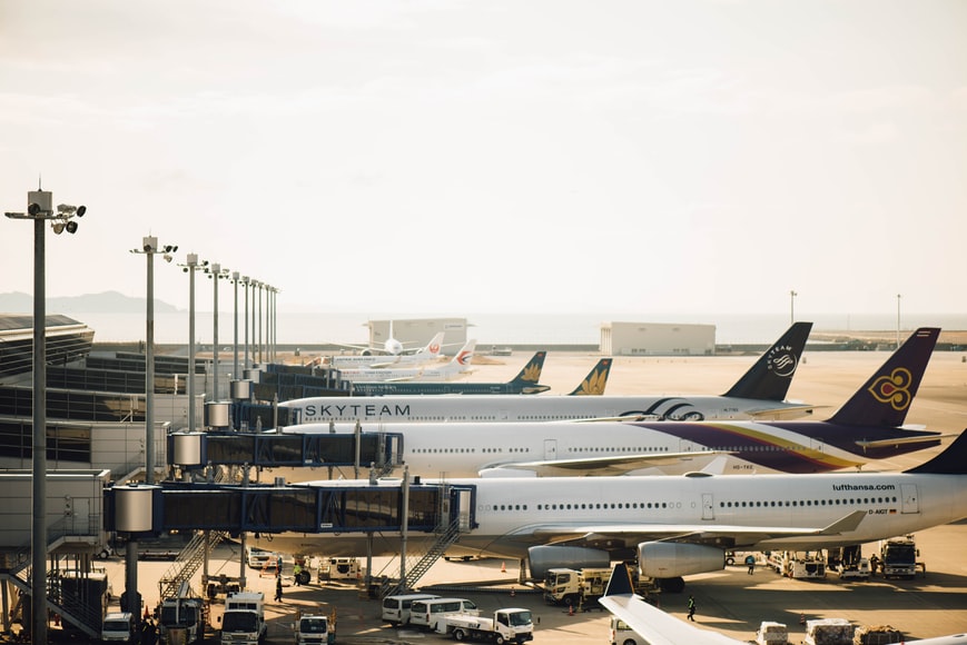 Four docked airplanes being serviced according to the correct airport operations.