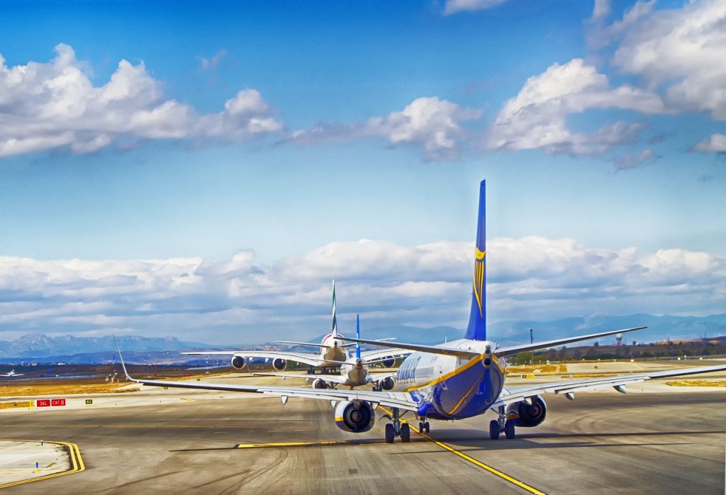 Multiple aircraft taxiing on a taxiway at an airport. 