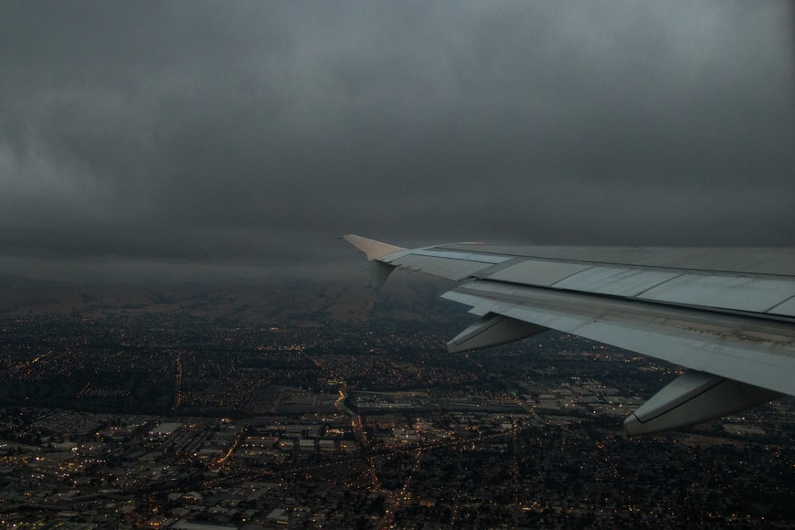 An aircraft flying through bad weather conditions: wind and rain.