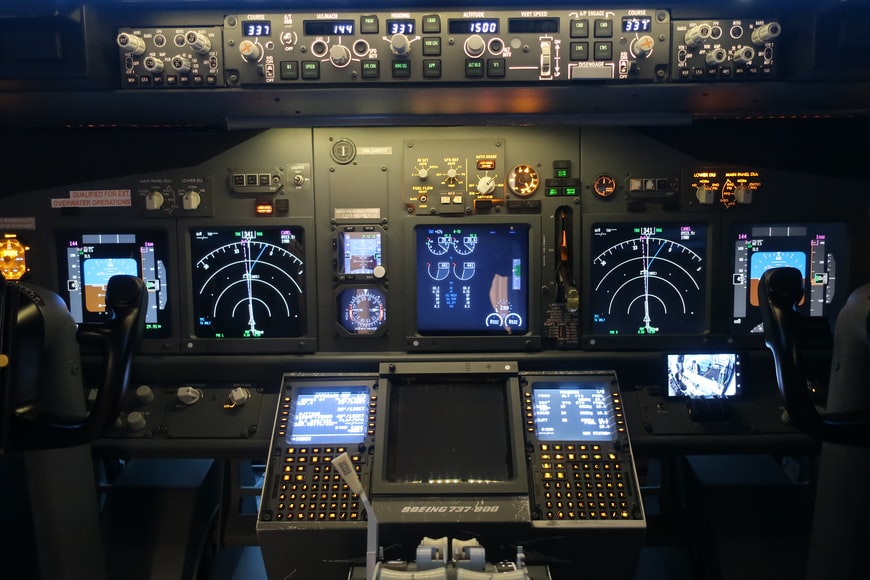 Cockpit of a Boeing 737-800 with various pieces of equipment showing data and aviation acronyms. 