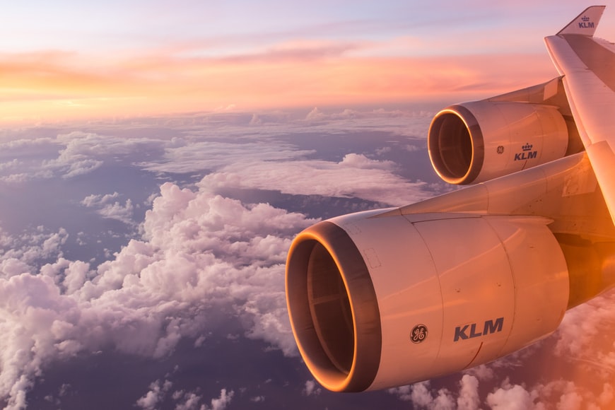 A KLM aircraft flying through a cloudy sky with a possibility of light turbulence.