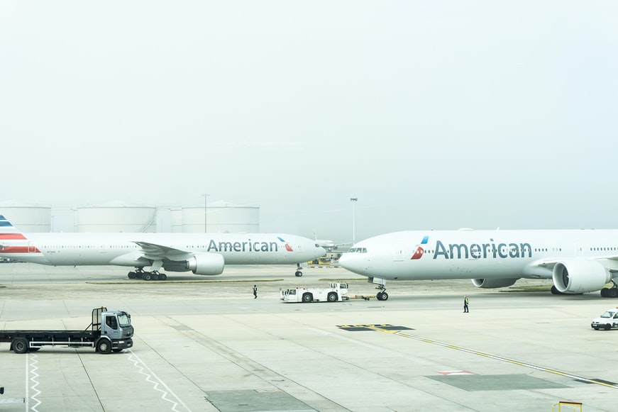 American airlines aircraft being pushed down the taxiway at an airport.