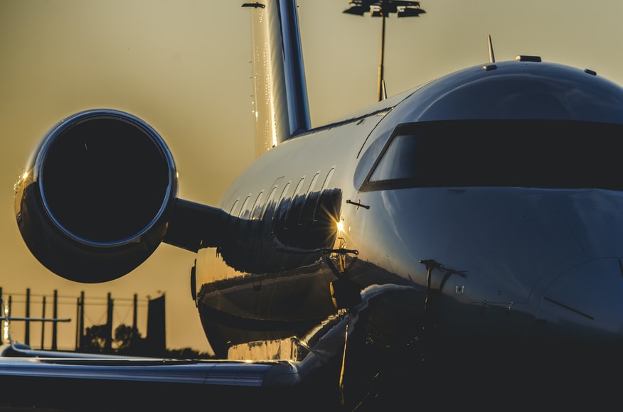 A side-view of a reflective private jet and one of its engines.