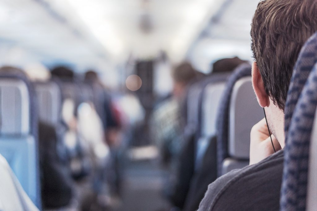 Passengers in an aircraft sitting in their seats.