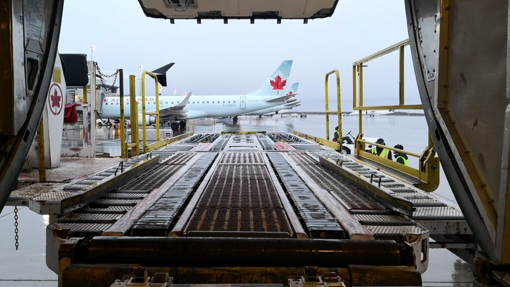 An aircraft being provided below the wing FBO services like baggage handling.