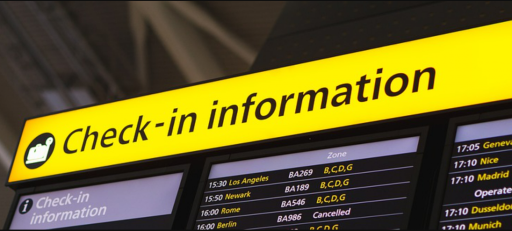 A board at an airport displaying check-in information for passengers. 