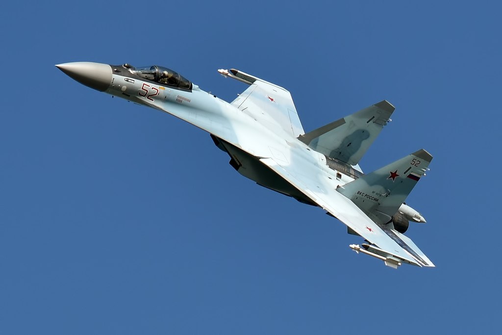 One of the best Fighter Jets in the World. Sukhoi Su-35 fighter jet flying through a blue sky.