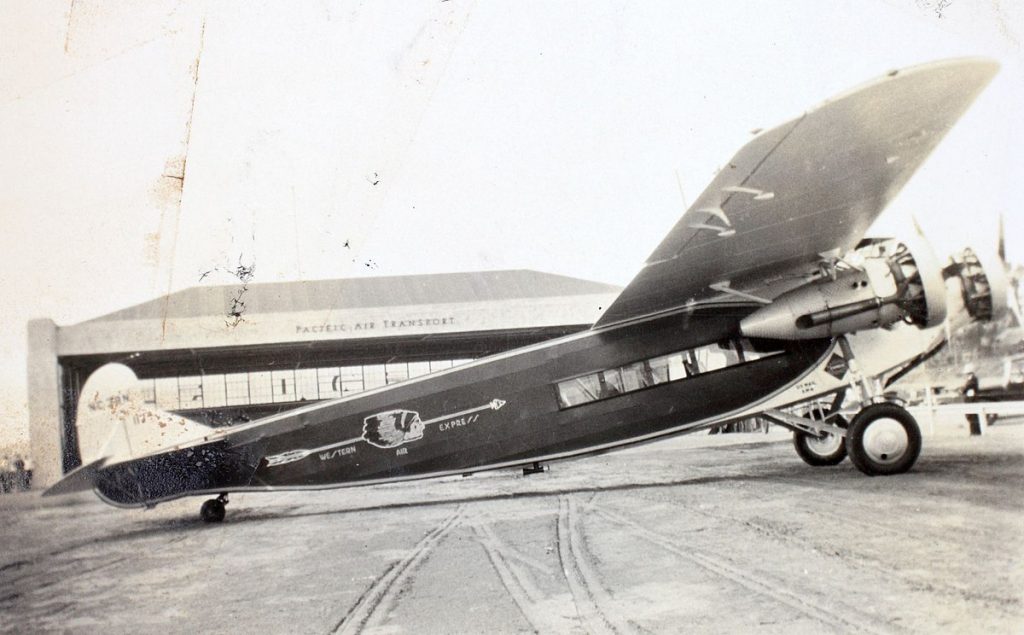 Western Air Express Fokker F.10 aircraft parked on a tarmac of an airport. 