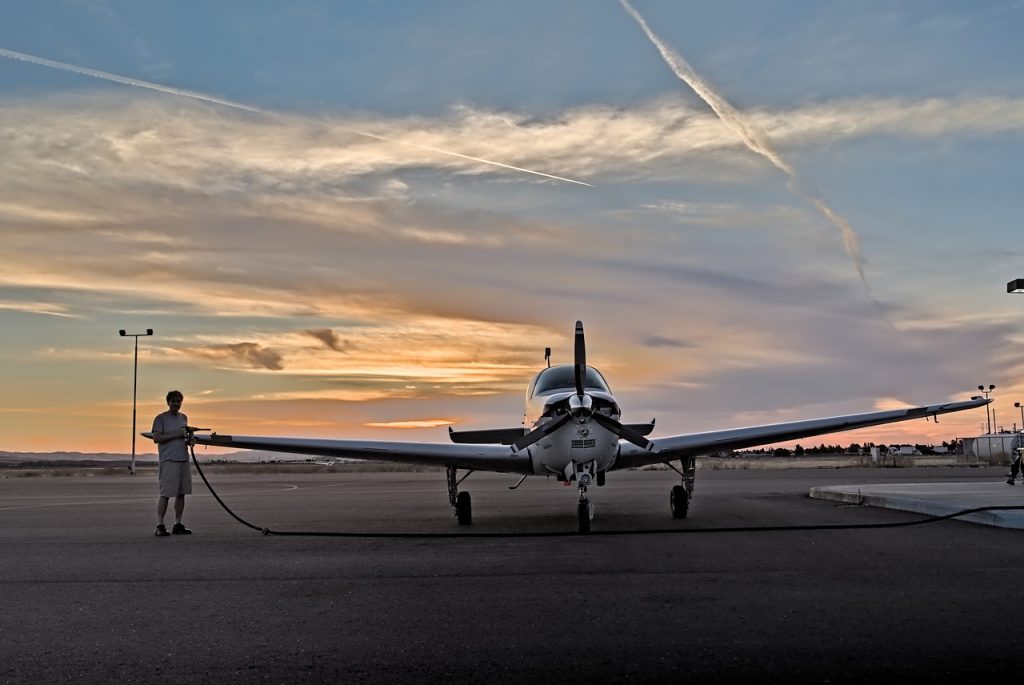 A small private aircraft being refueled by its pilot. 