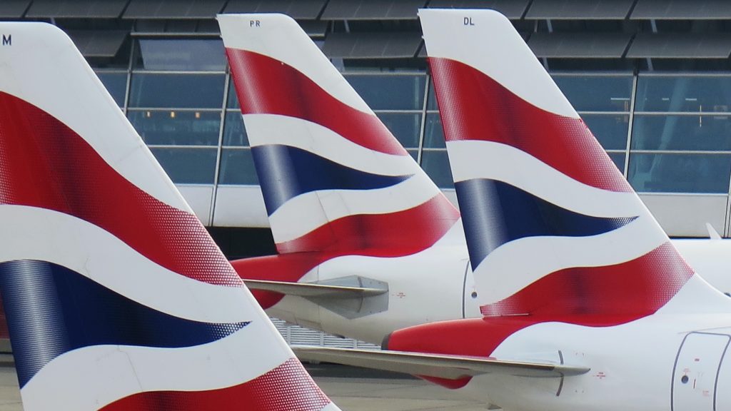 Three airplane tails decorated with a blue and white flag.