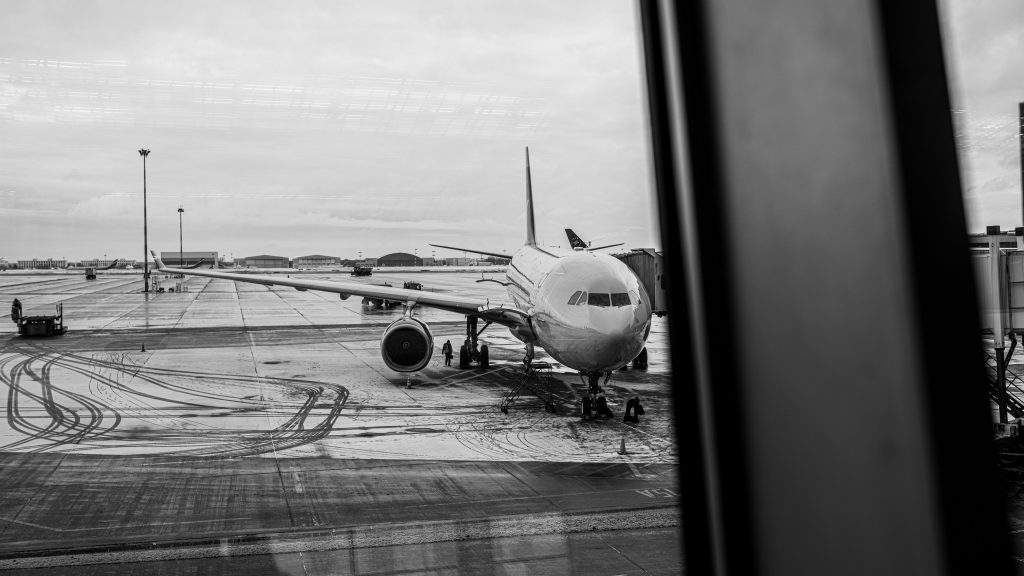 An airplane parked at jetway on a snowy icy tarmac.