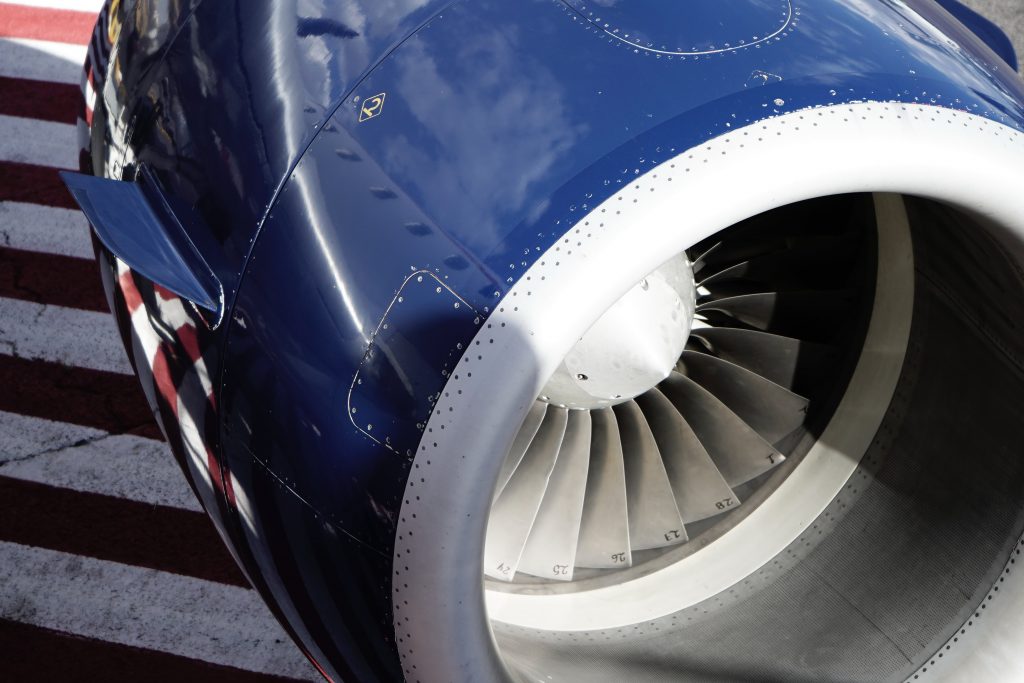 A central image of an aircraft engine painted in dark blue.