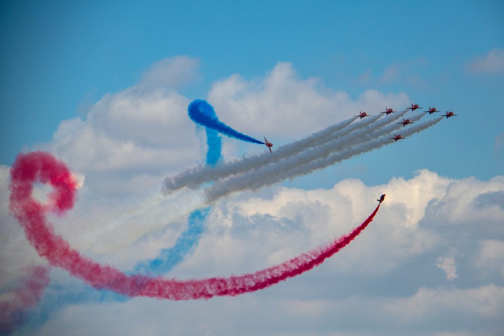 An acrobatic air show in which differently coloured smoke oil is used: blue, red, and white.