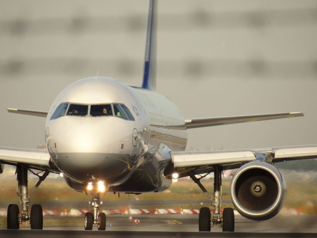 A view of a taxiing aircraft with rotating aircraft engines and bright front lights.