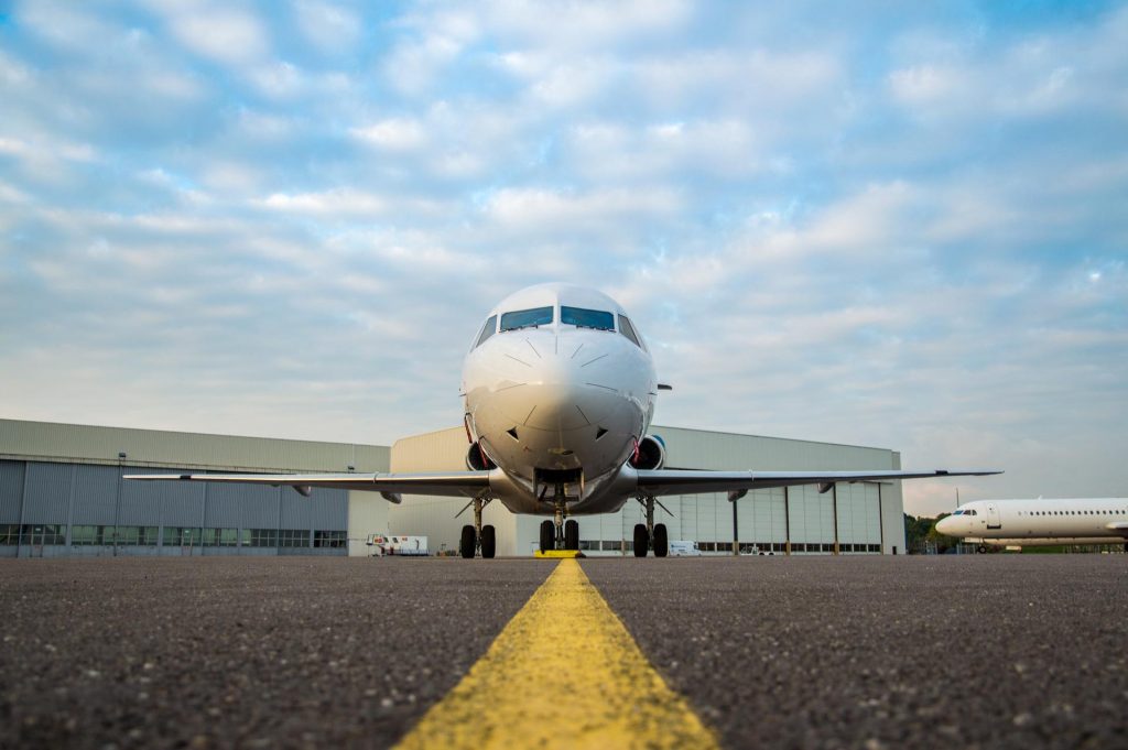 A central view of an aircraft facing the camera, parked on a tarmac of an airport.