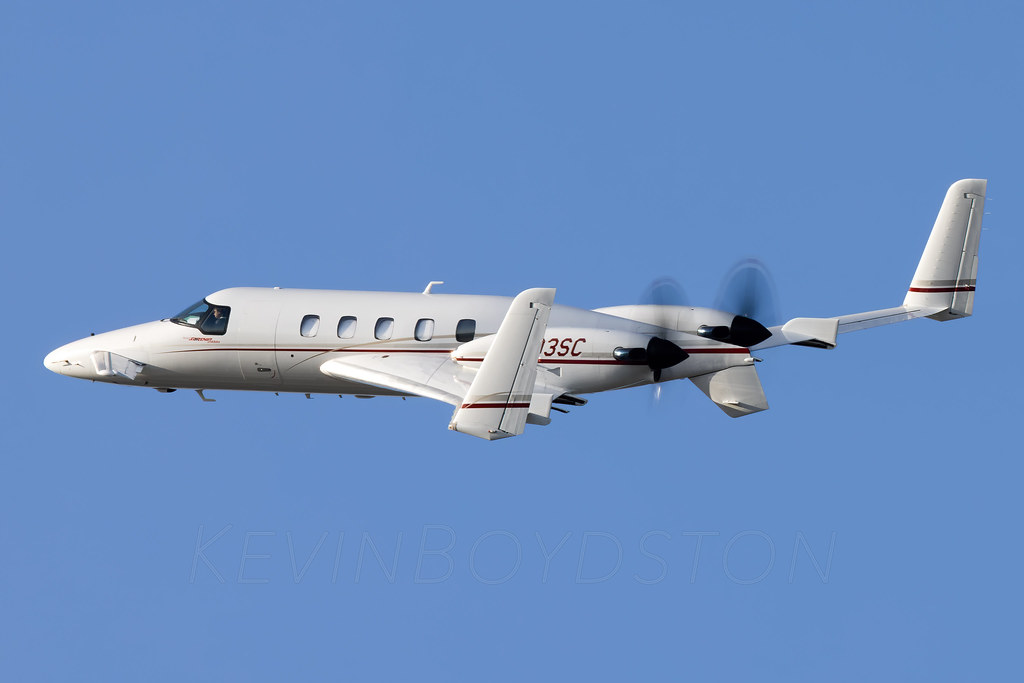 A Beechcraft starship in flight across a blue sky.