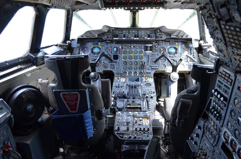 A cockpit of an aircraft: pilot seats, control column and the instrument panel.
