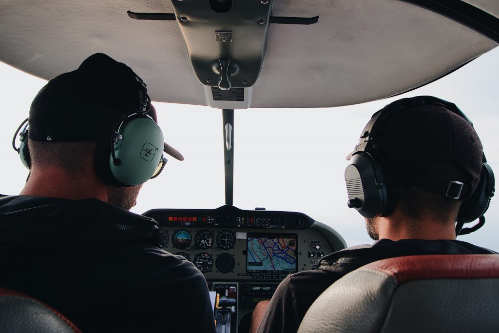 Two private pilots maneuvering a small plane. 