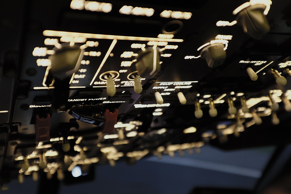 A control panel with illuminated buttons and switches onboard an aircraft. 
