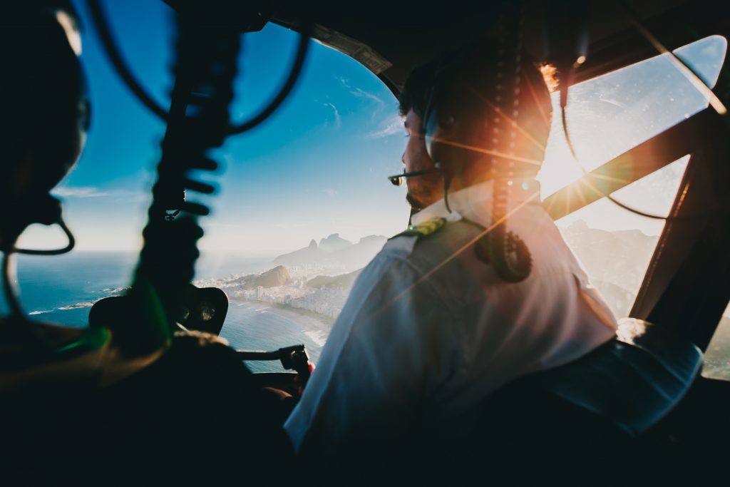 A student pilot an an instructor flying a small aircraft over a bay. 