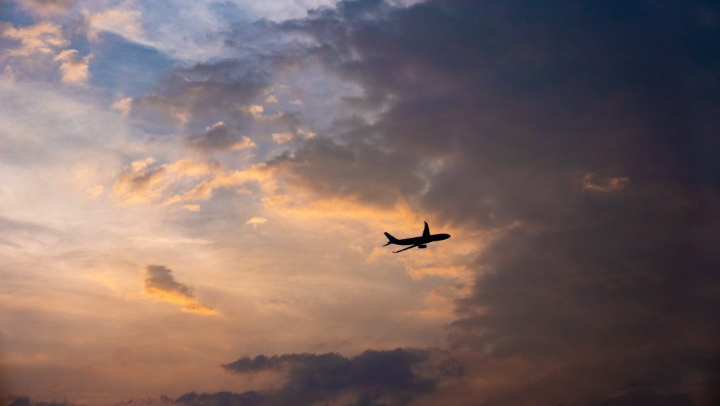 An aircraft performing a maneuver with the help of an autopilot system in an evening sky.