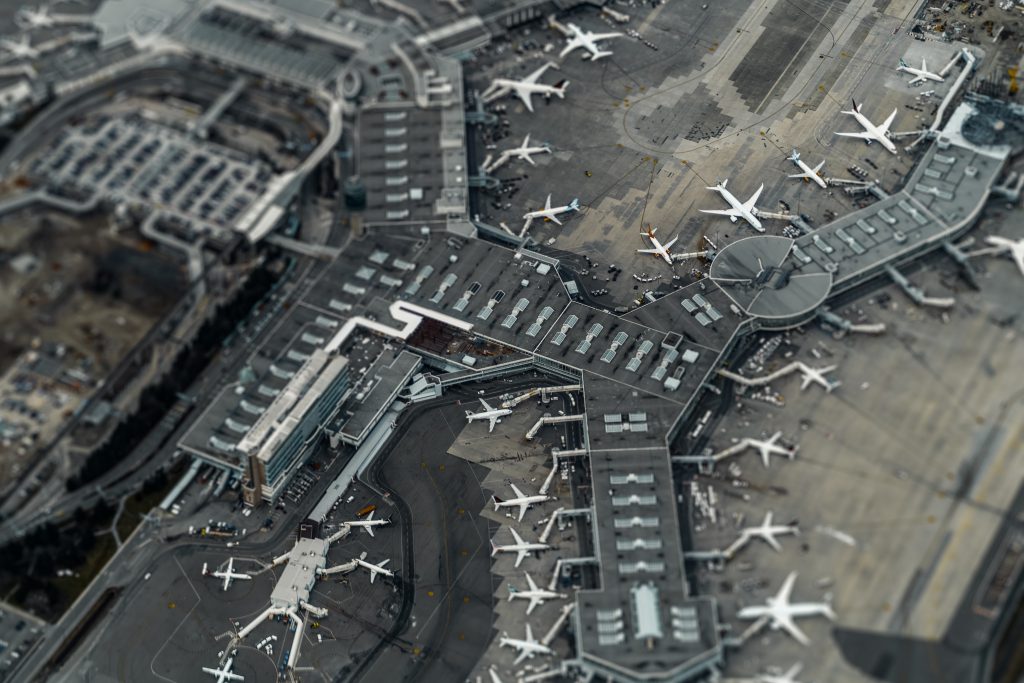 A bird's eye view of an airport terminal building and aircraft parked outside of it.