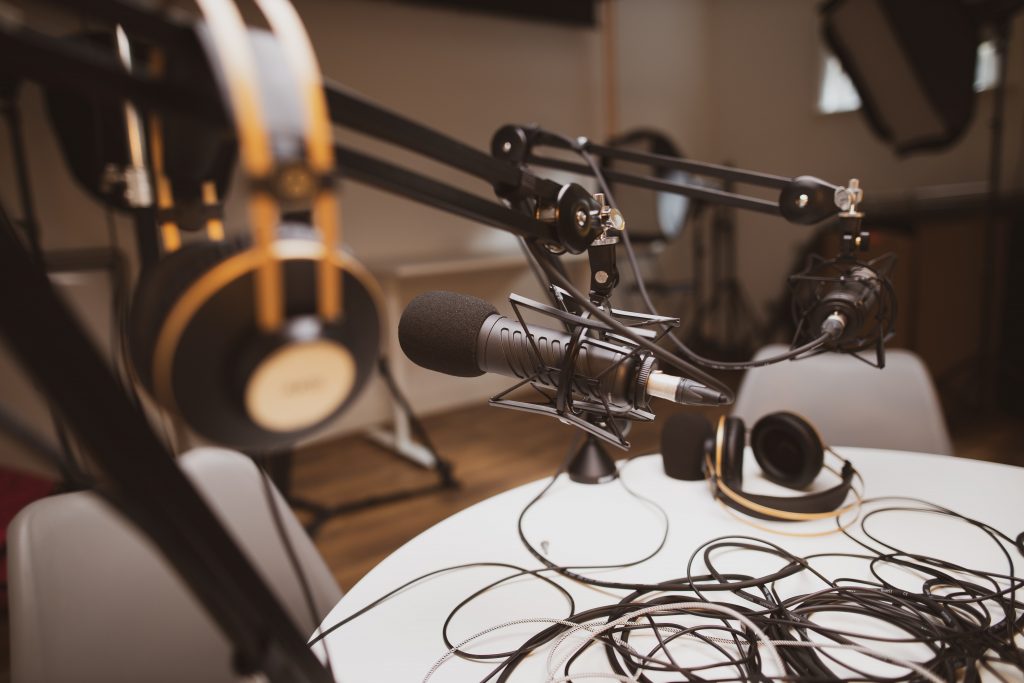 A view of podcast recording equipment: a microphone on a stand and a set of headphones.