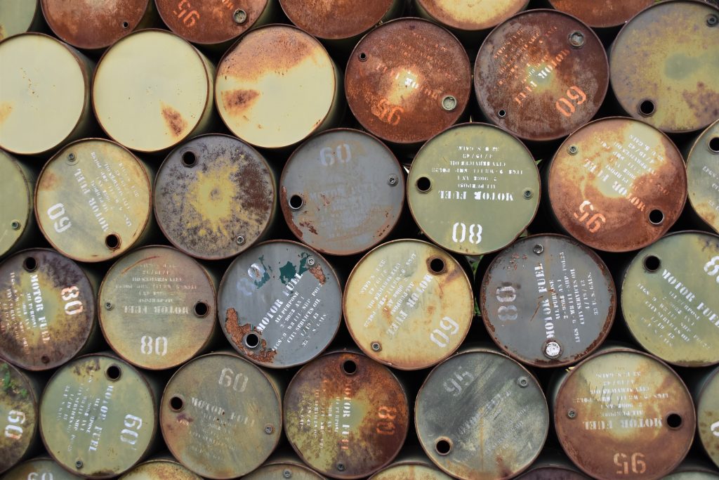Rusty petrol barrels stacked on top of each other.