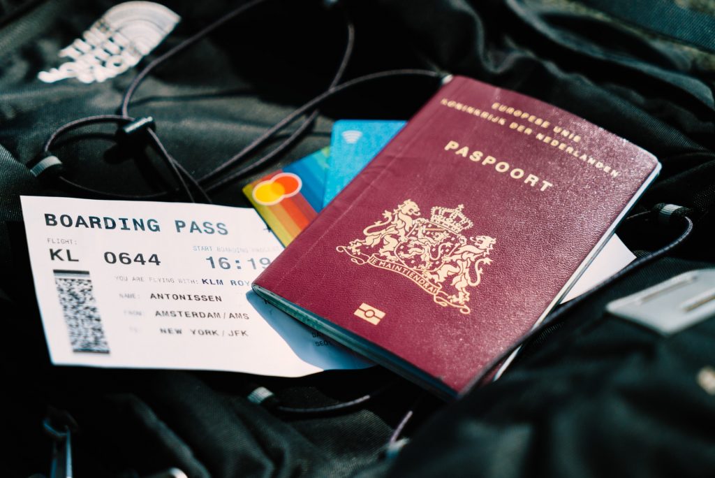 A boarding pass, credit cards and a passport placed on a travel bag.