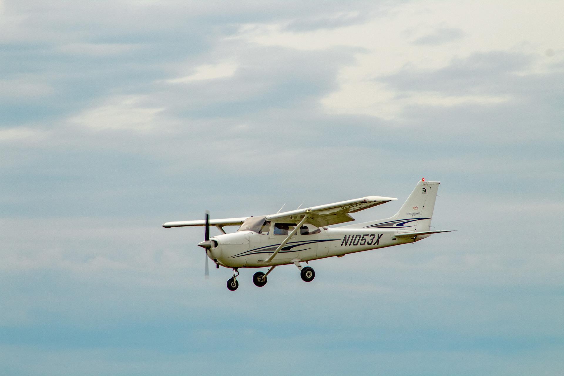 A small airplane, Cessna 172, flying across the sky.