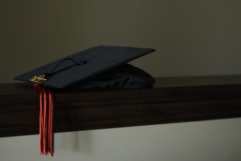 A university graduation cap laying on a shelf.