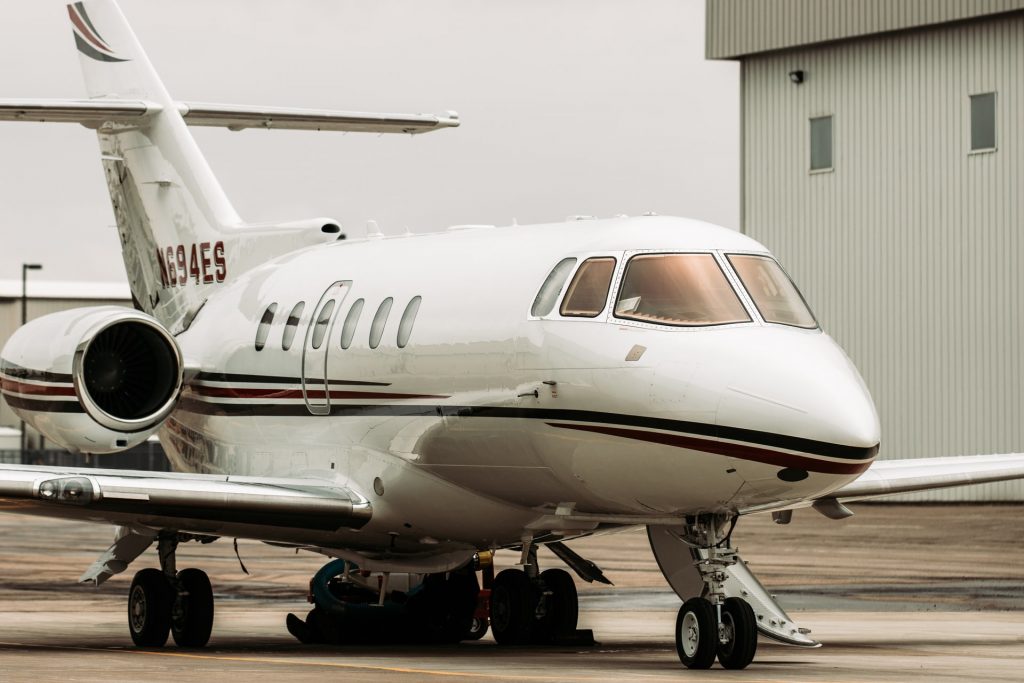 A private jet stationed at the airport on a cloudy day. How much does a plane cost?