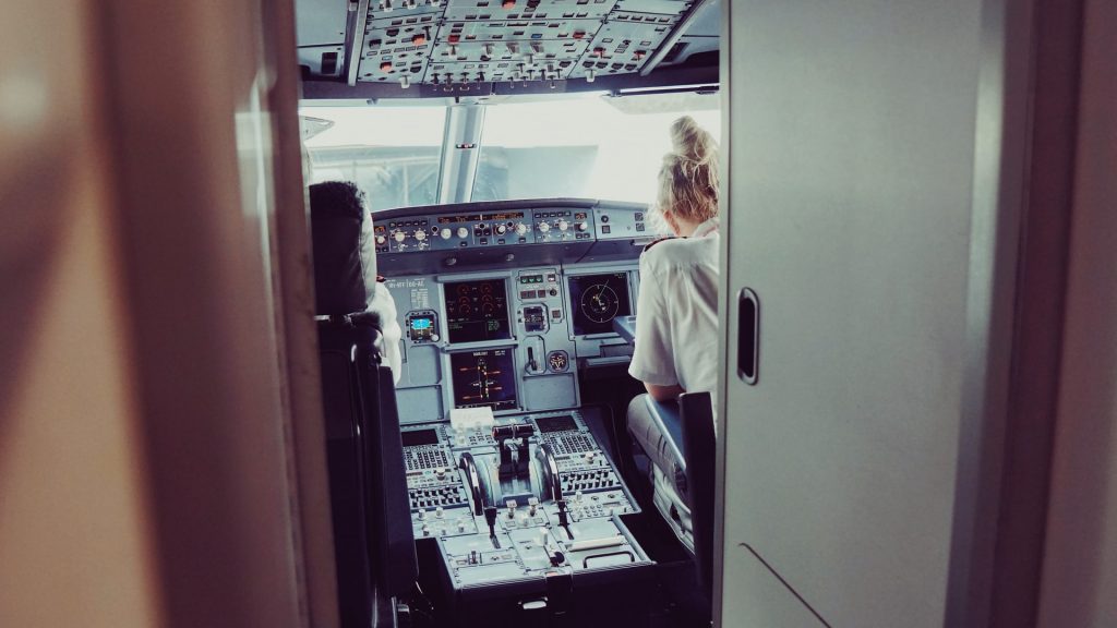 A female pilot preparing for a flight in the cockpit of an aircraft. 